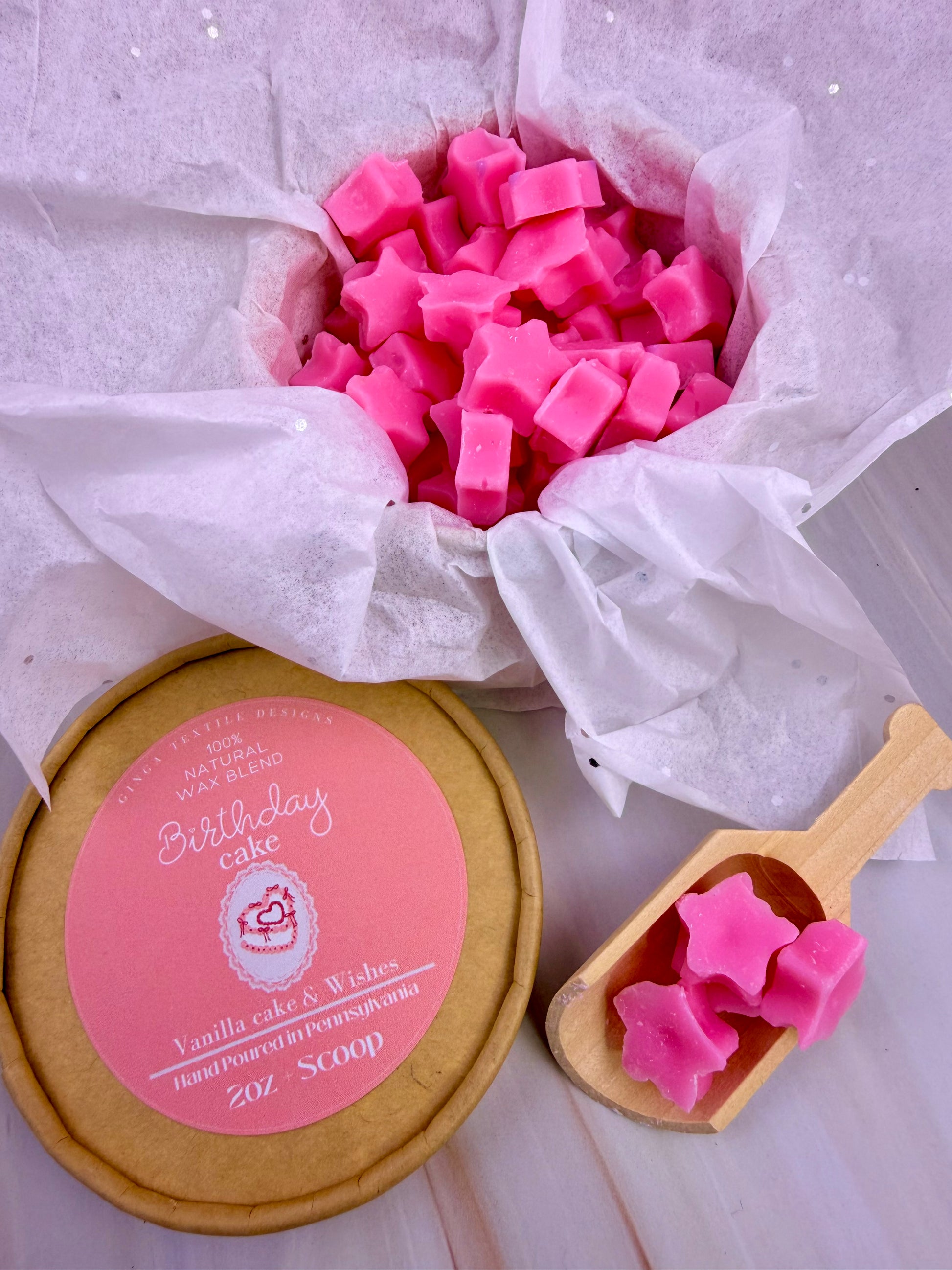Pink star-shaped wax melts in a container with a lid, on a light background.