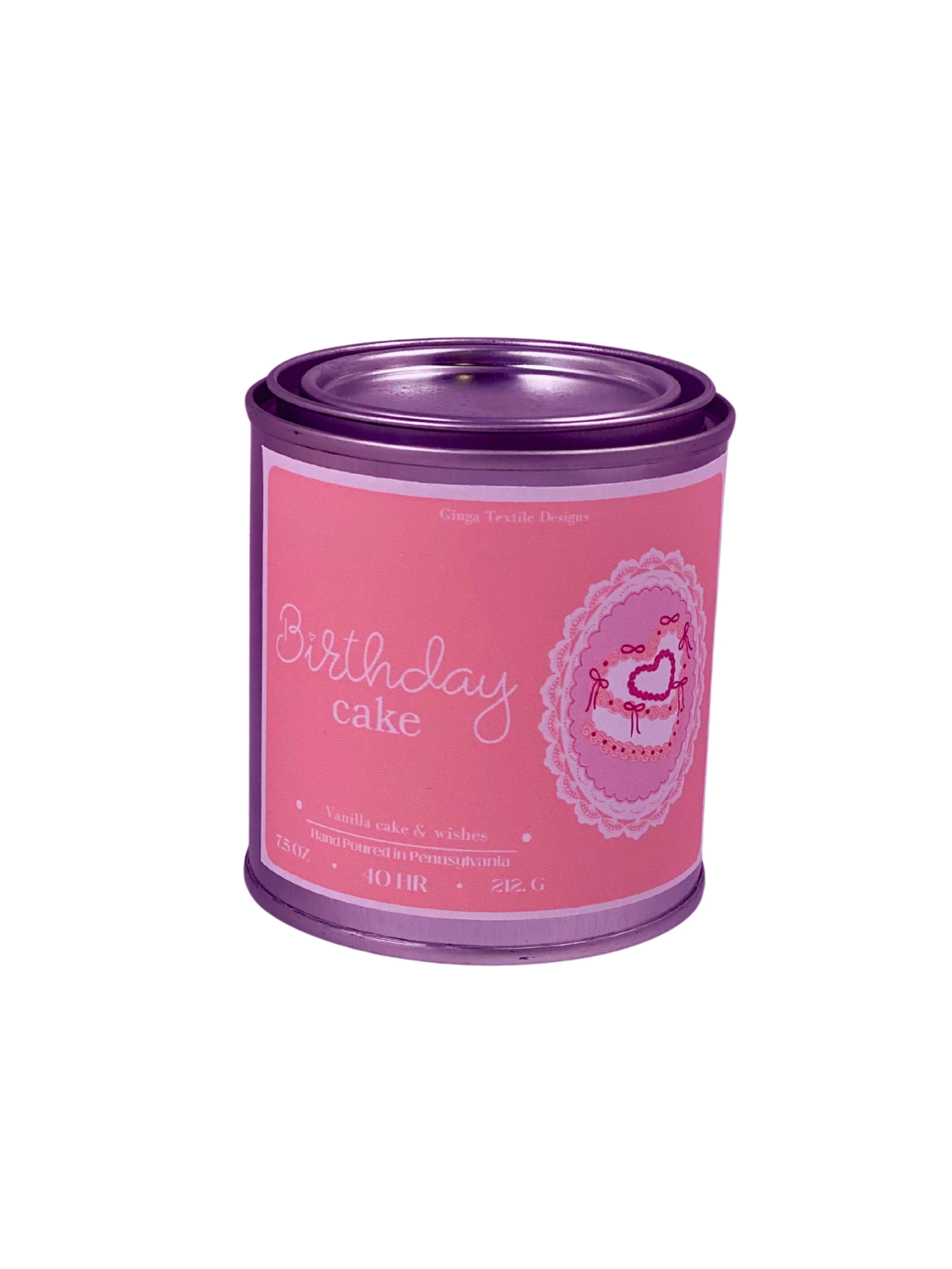 Pink candle with metal lid labeled 'Birthday Cake' on a white background