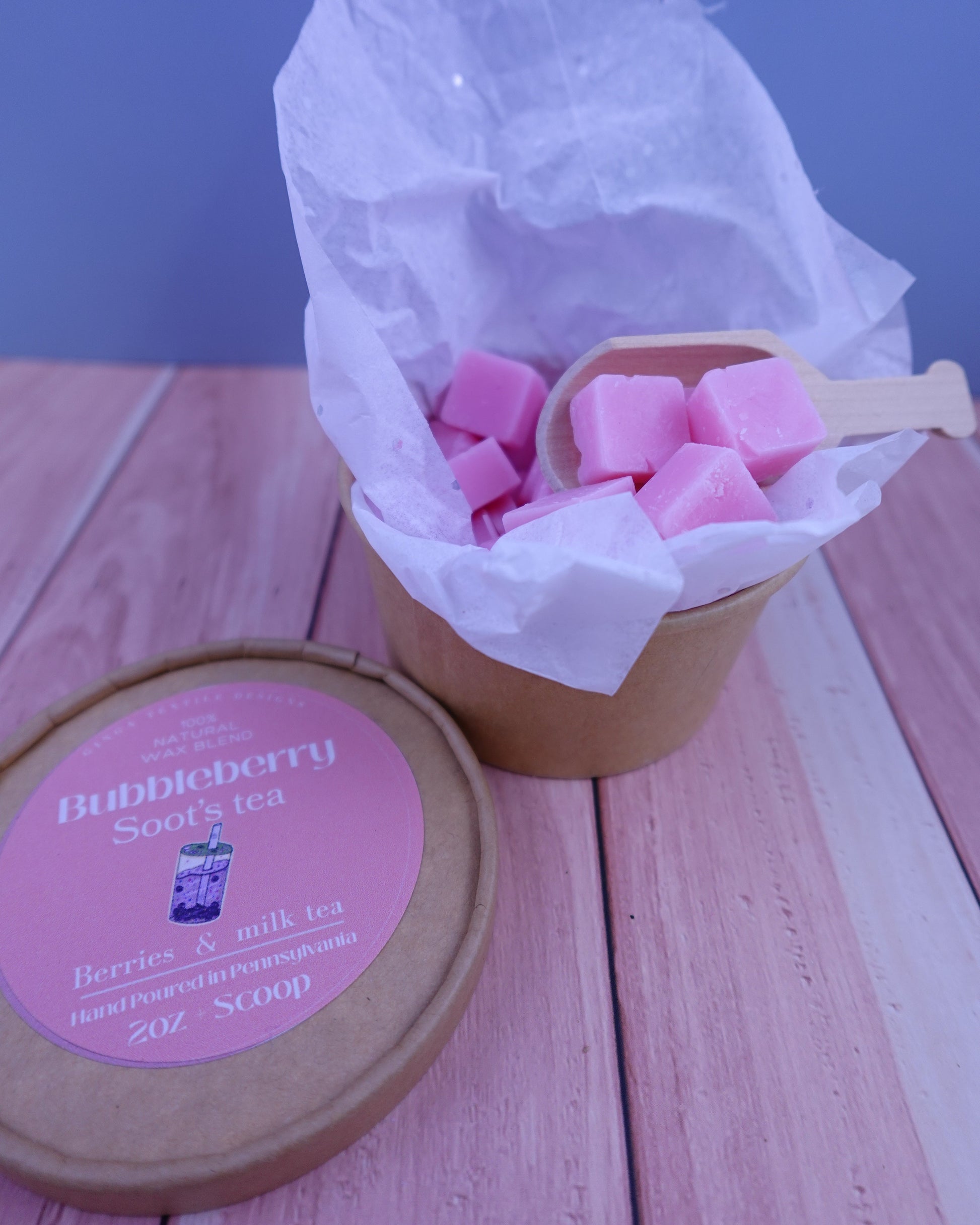 Pink wax melts in a paper cup on a wooden surface with a blue background