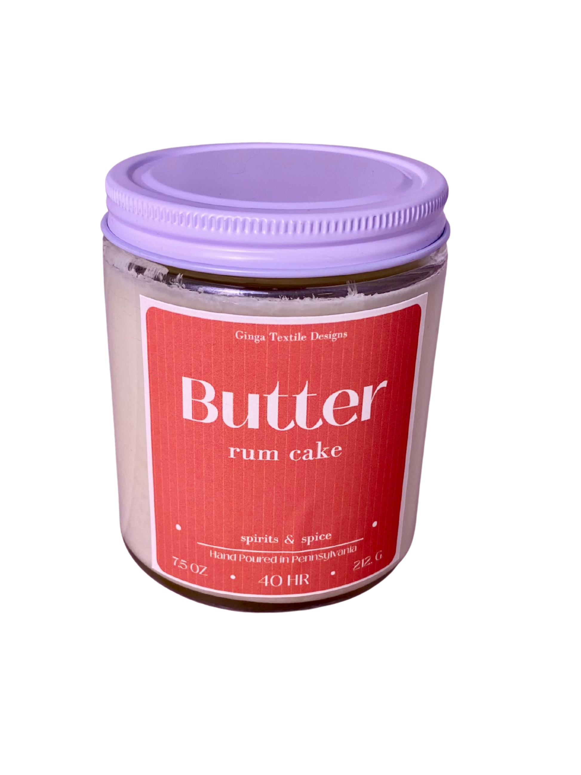 Clear glass jar of 'Butter Rum Cake' candle with a white lid on a white background