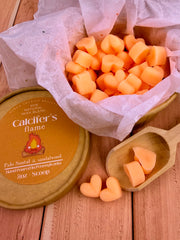 Calcifer's Flame wax melts cubes in a wooden scoop on a wooden surface