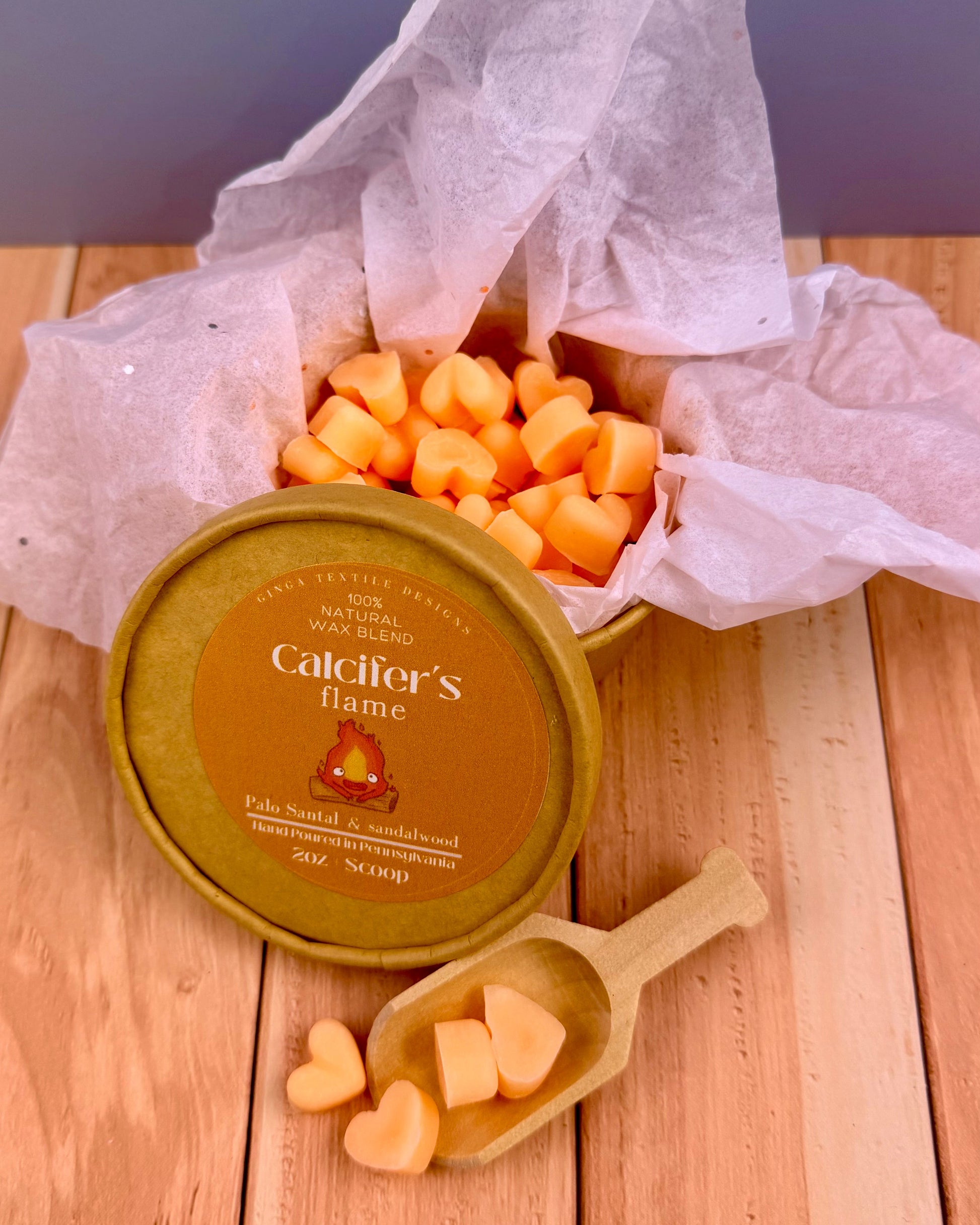 Container of Calcifer's Flame with heart-shaped cheese pieces on a wooden surface