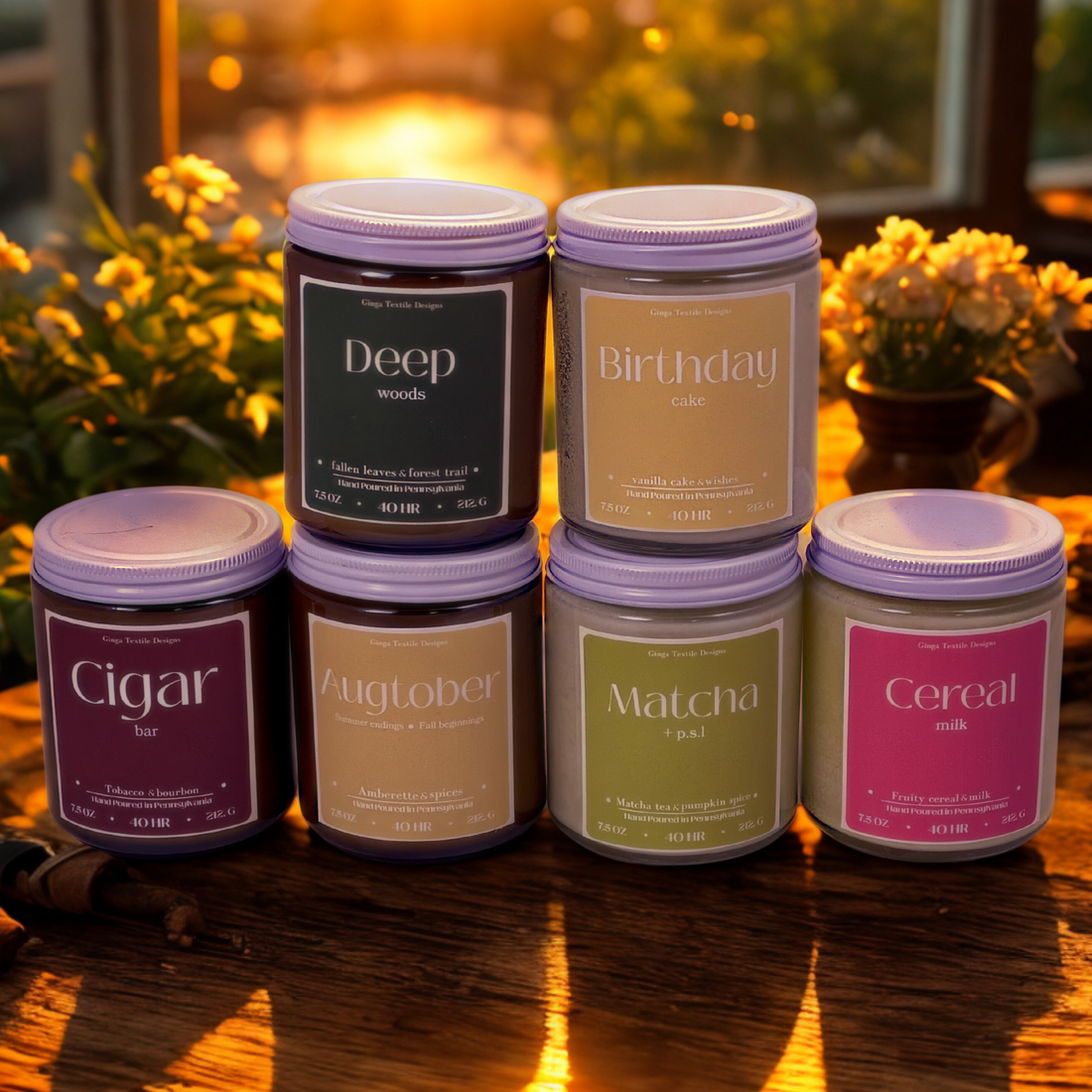 Set of candles with labels on a wooden surface with a sunset and flowers in vases in background