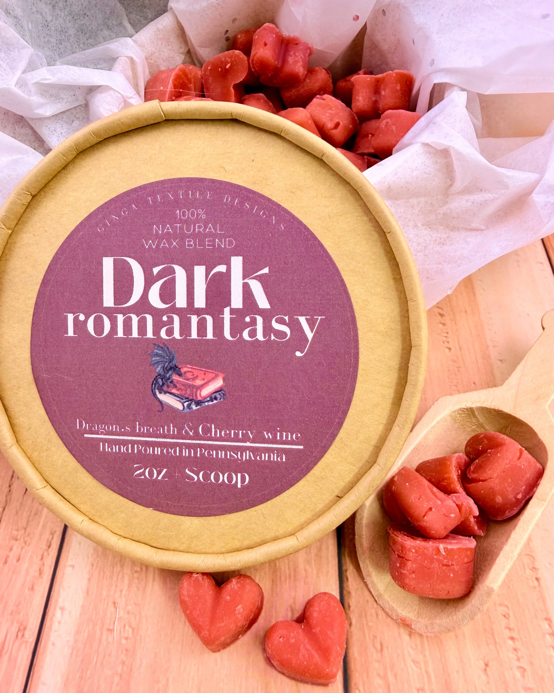Wax melts in heart shapes with a cardboard lid that has a label on it for the scent Dark Romantasy