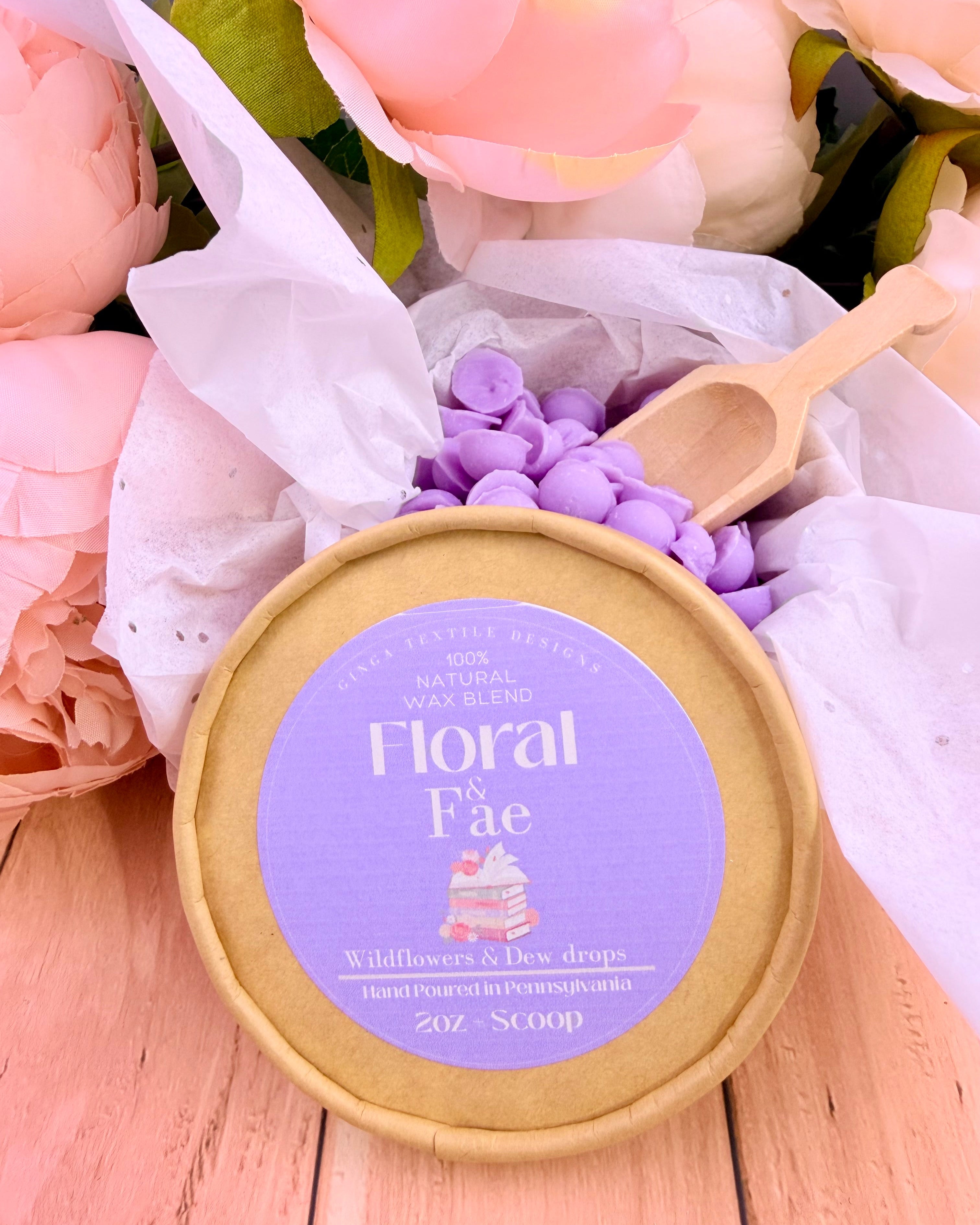 Floral and Fae wax melts with flowers and wooden spoon on a wooden surface