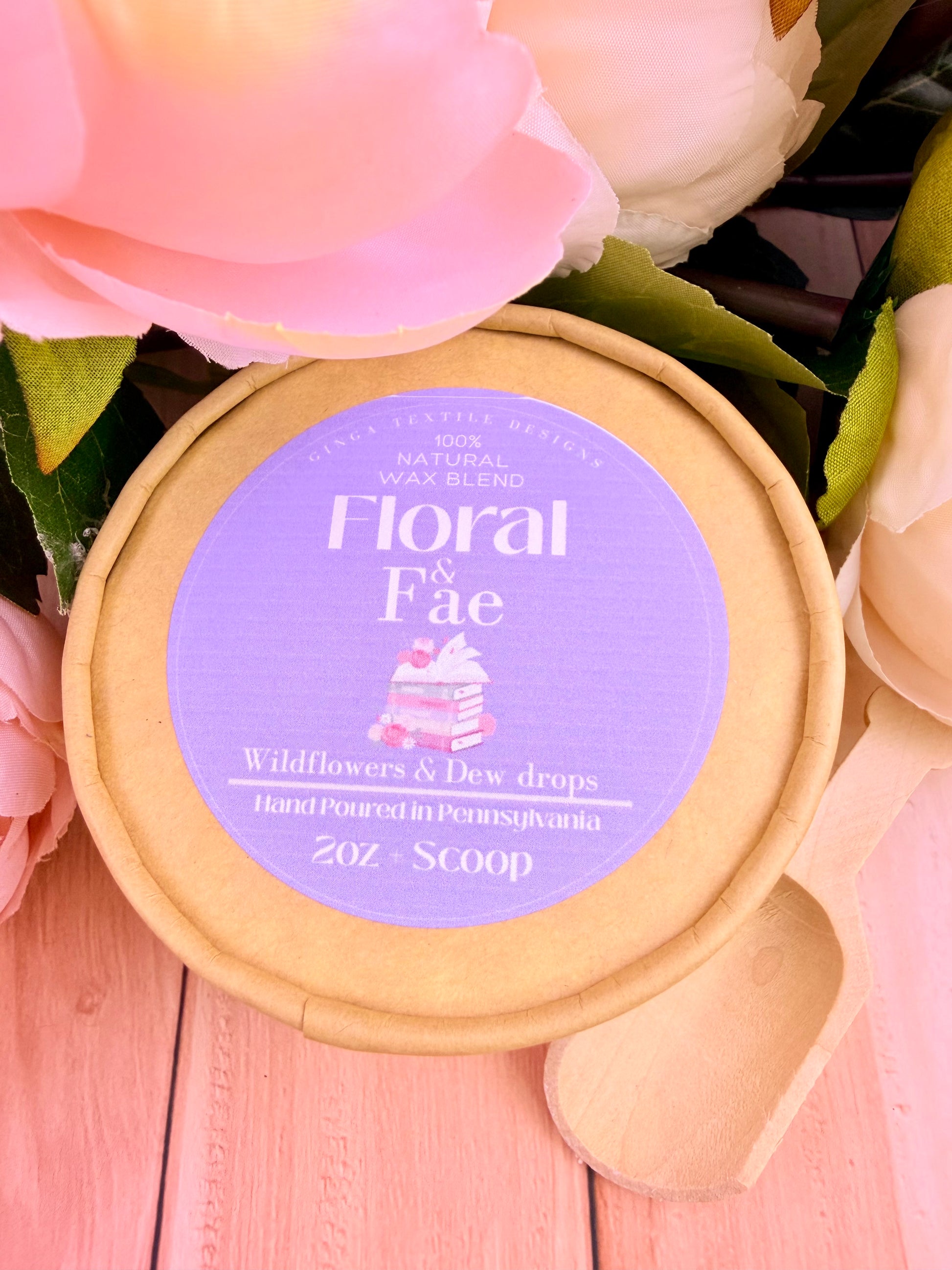 Wax blend container labeled 'Floral Faé' with pink flowers in the background