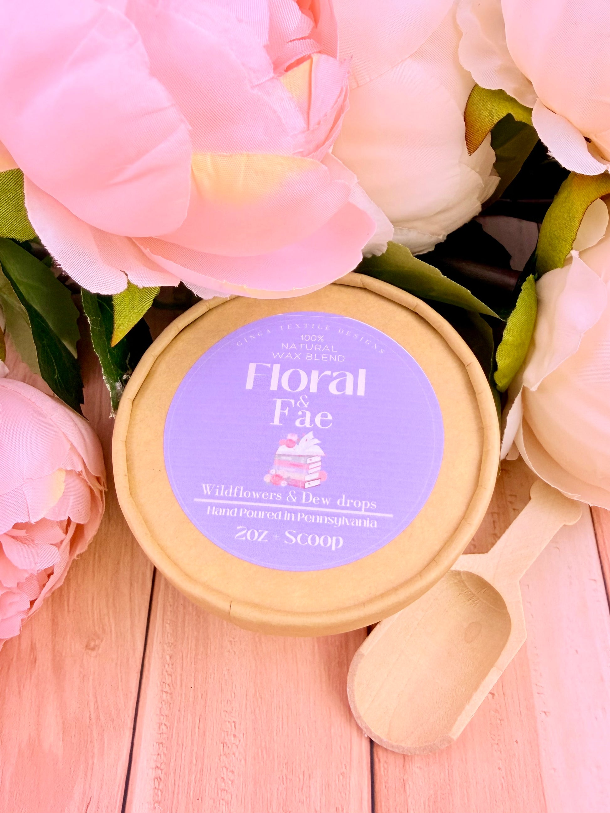 Container of 'Floral Fae' wax mel with pink flowers in the backgrounds