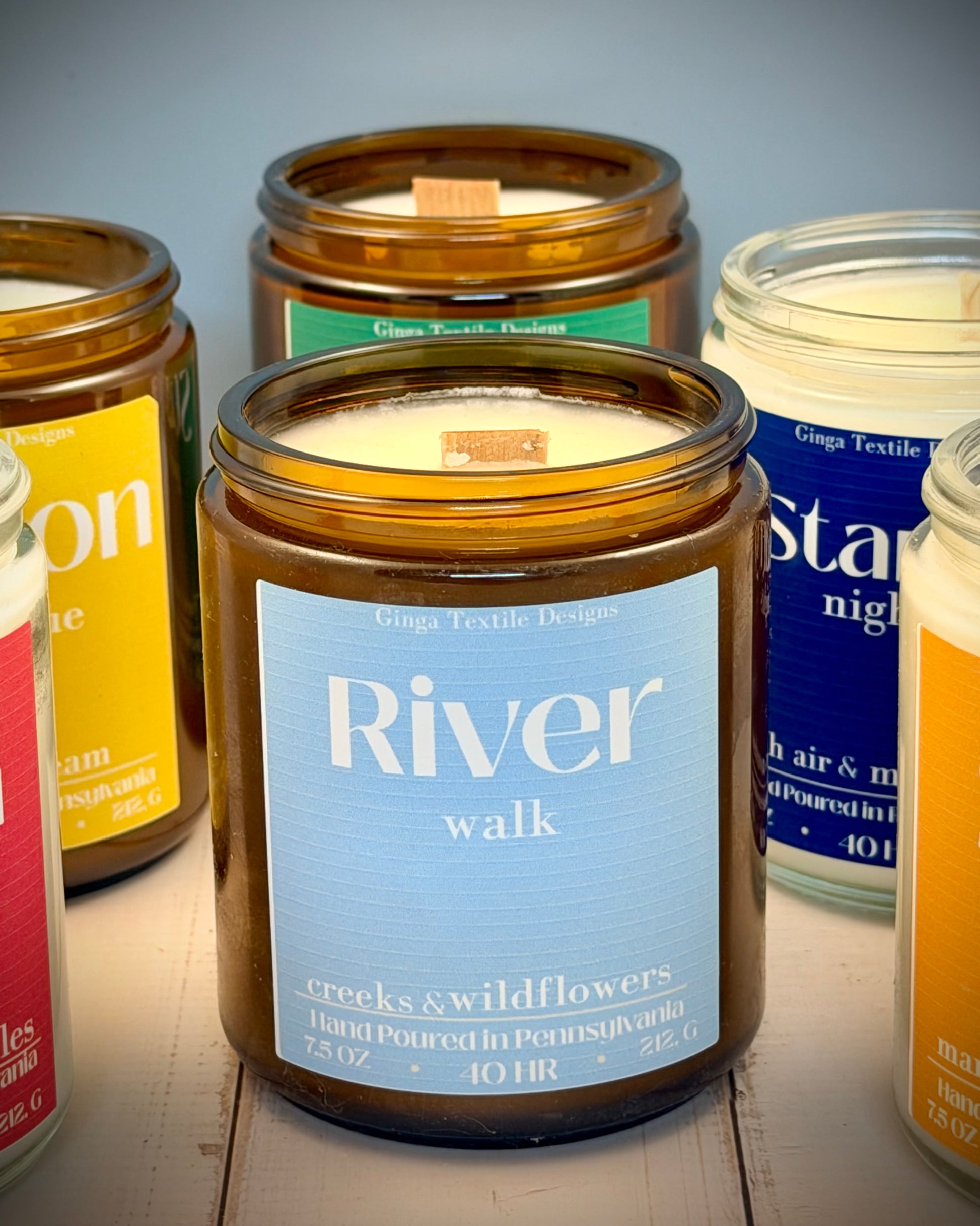 Collection of candles with visible labels on a wooden surface