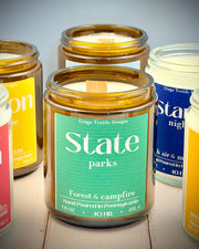 Collection of candles with visible labels on a wooden surface
