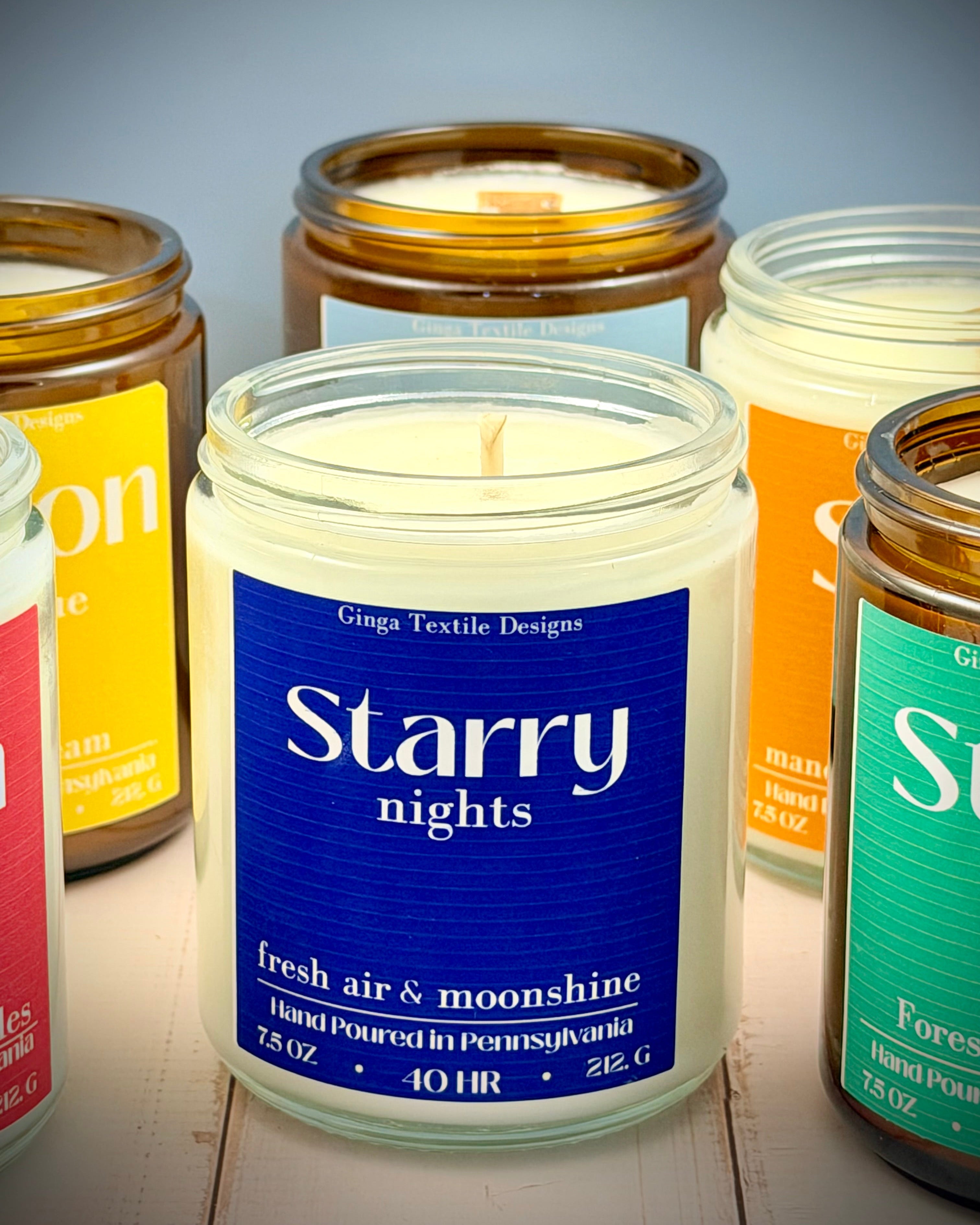 Collection of candles with visible labels on a wooden surface