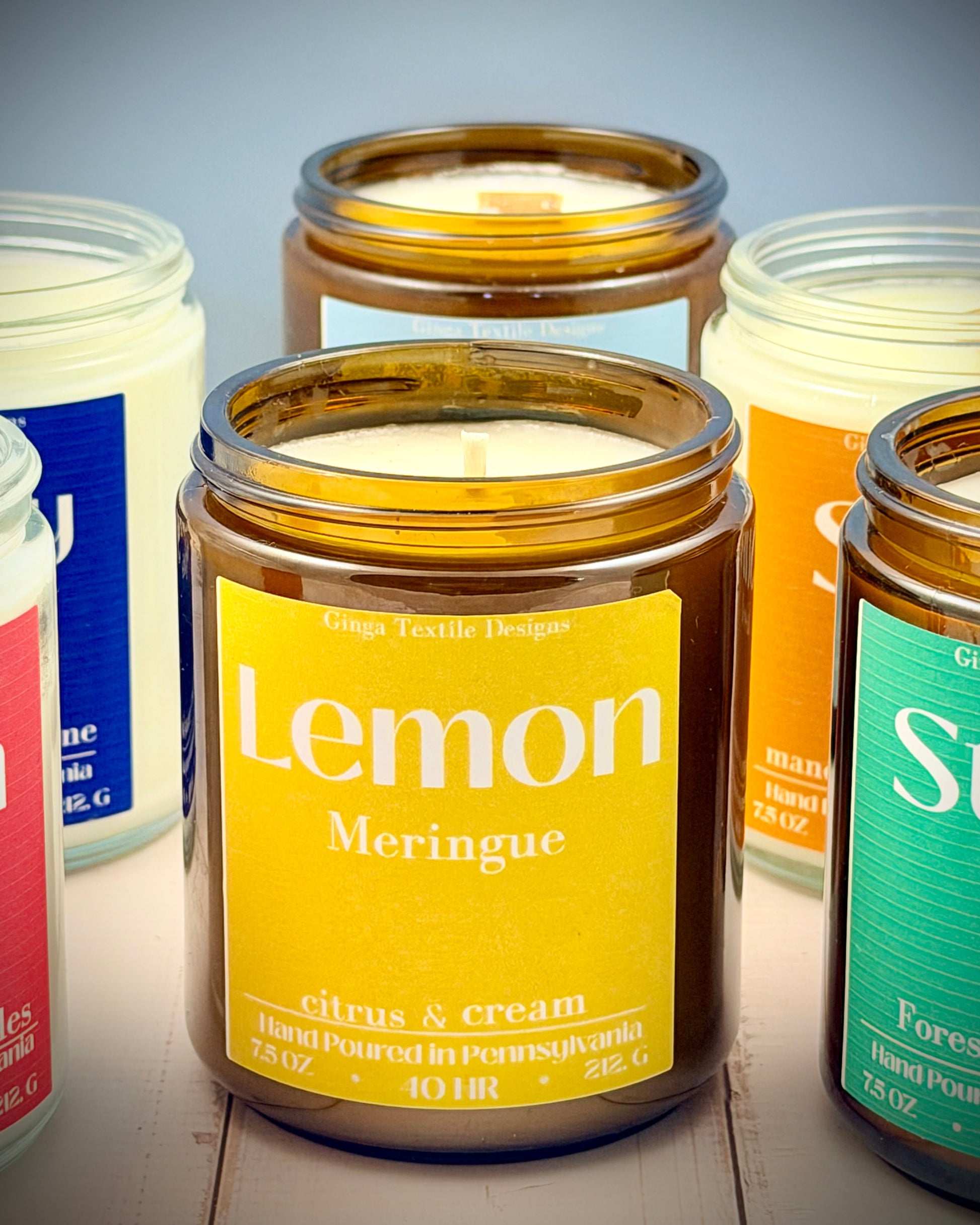Jar candles with colorful labels on a wooden surface