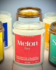 Collection of candles with visible labels on a wooden surface