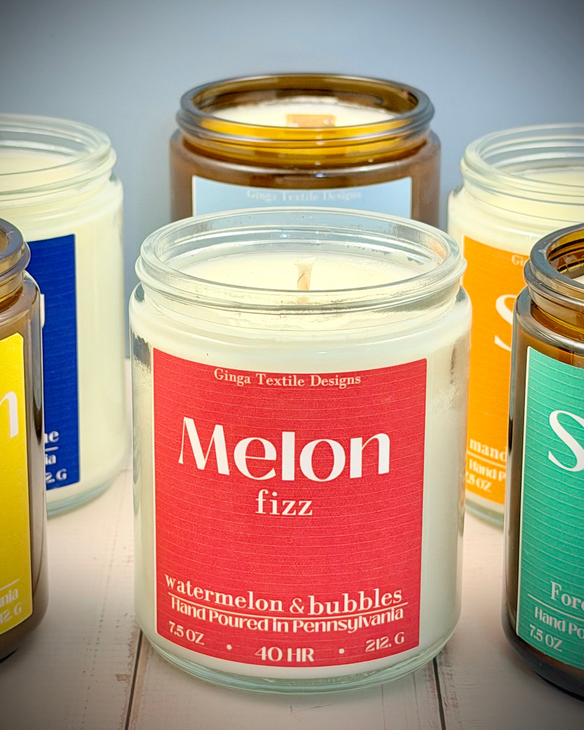Collection of candles with visible labels on a wooden surface
