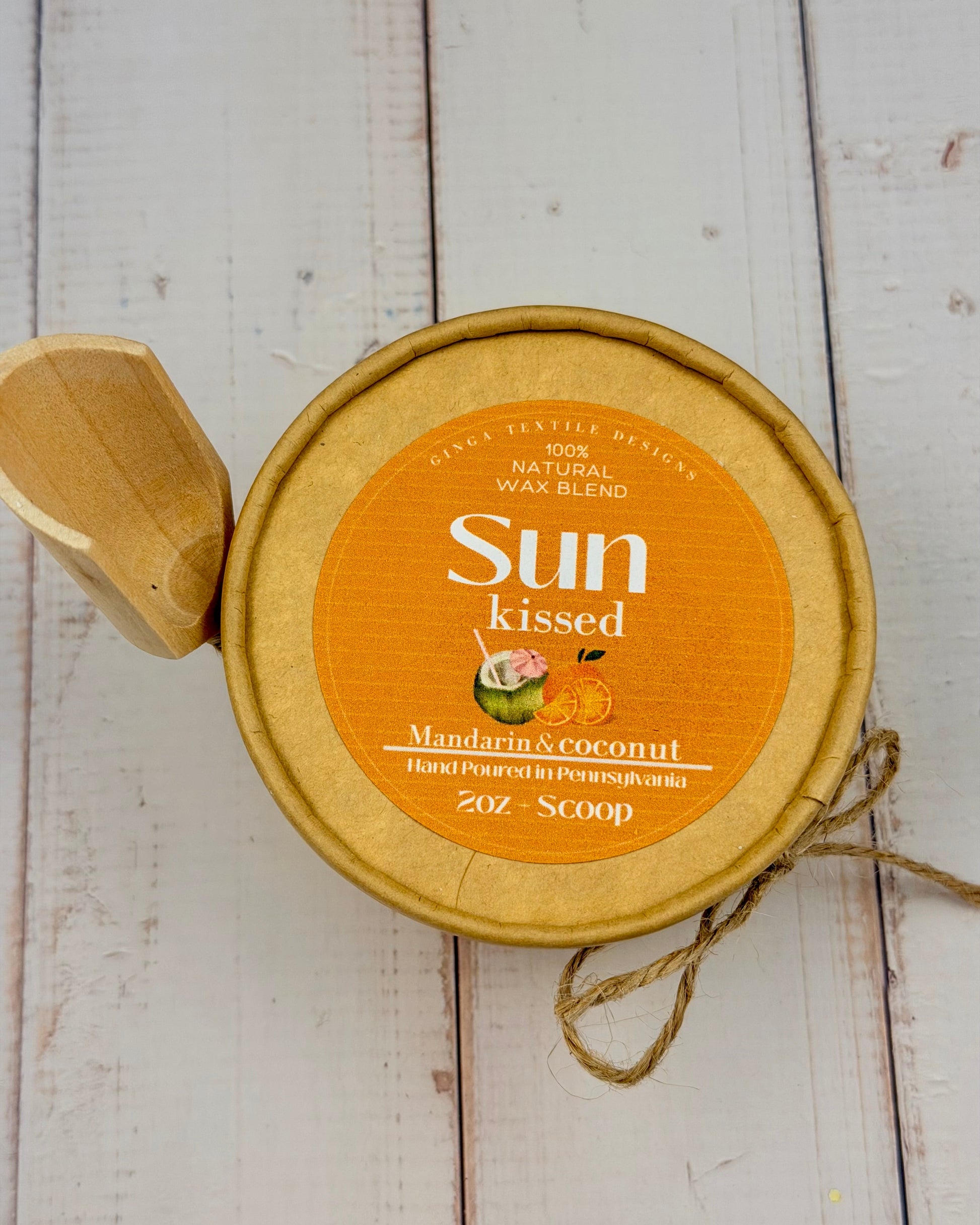 Sun-kissed Mandarin & Coconut wax melt container on a wooden surface
