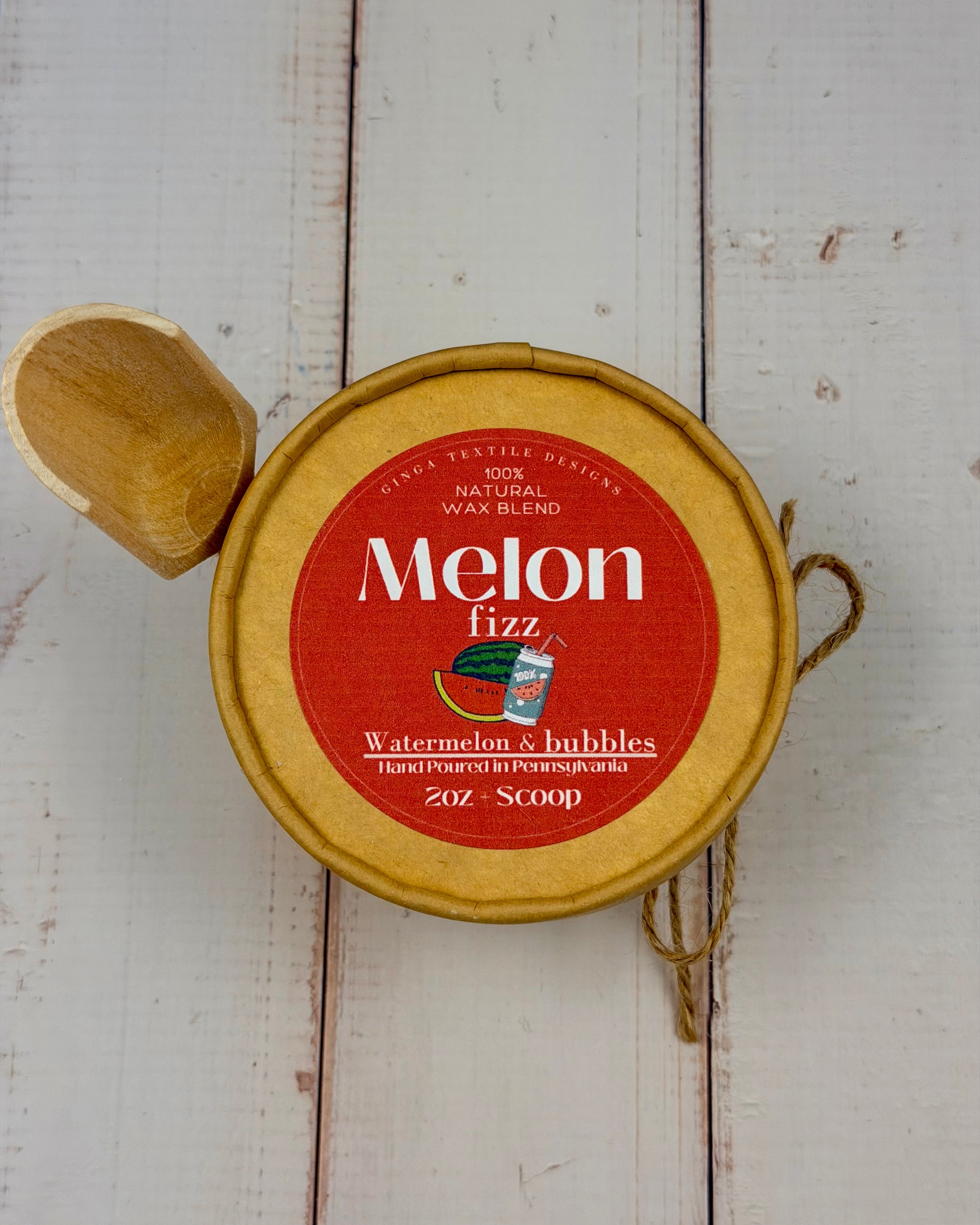 Wax blend container labeled 'Melon Fizz' with a wooden scoop on a wooden surface