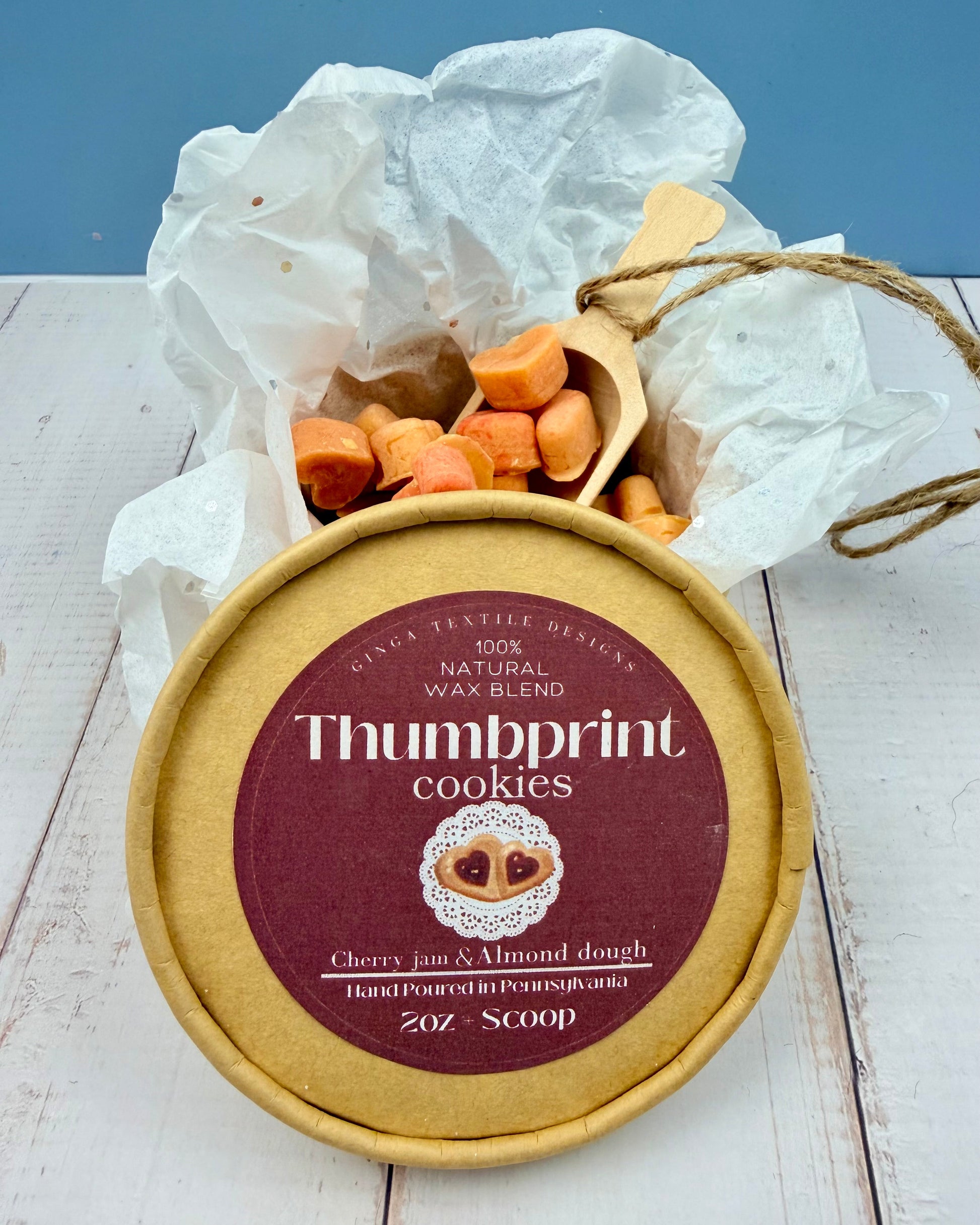 Wax tarts labeled 'Thumbprint cookies' on a white surface with a blue background