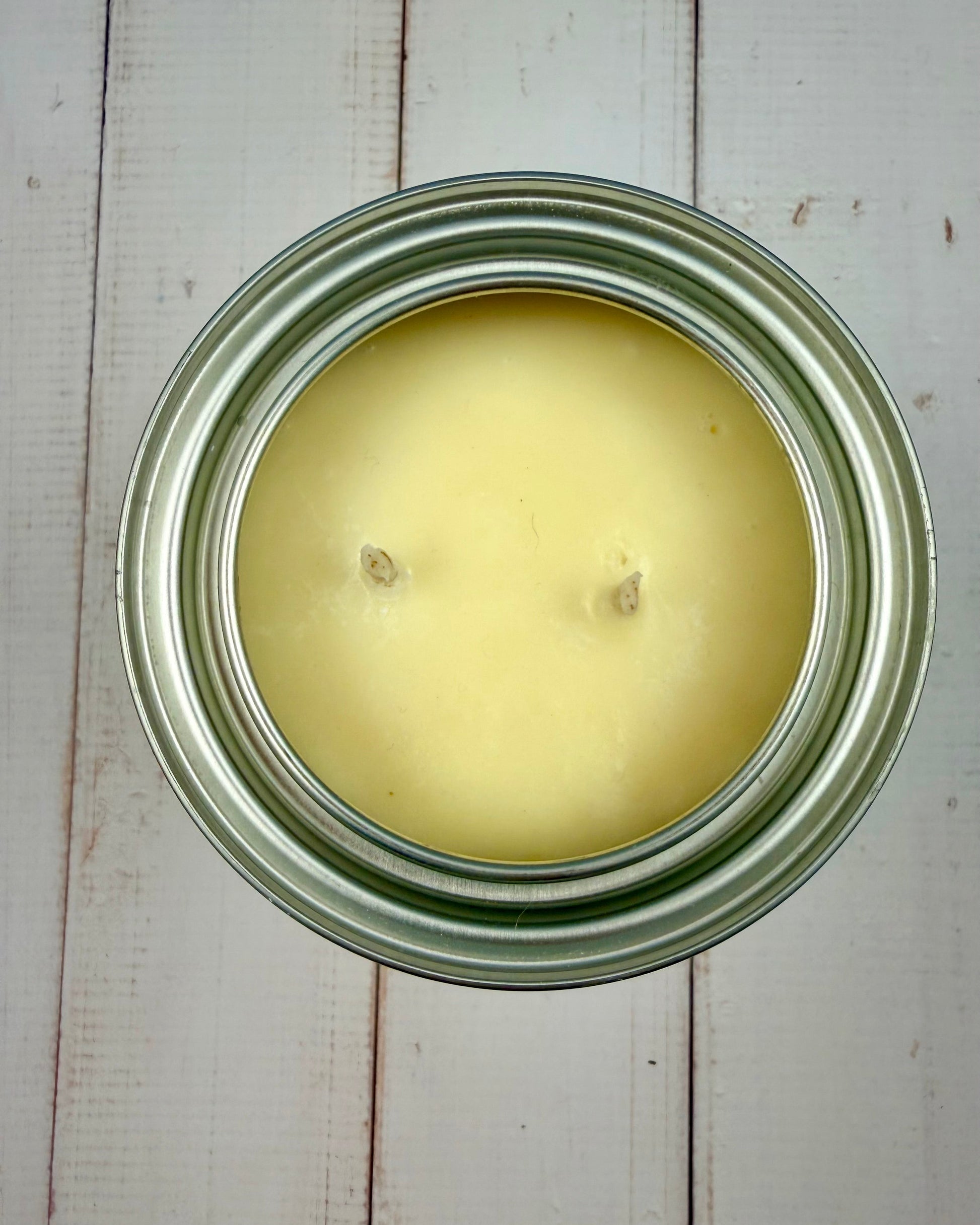 Candle in a metal jar on a wooden surface