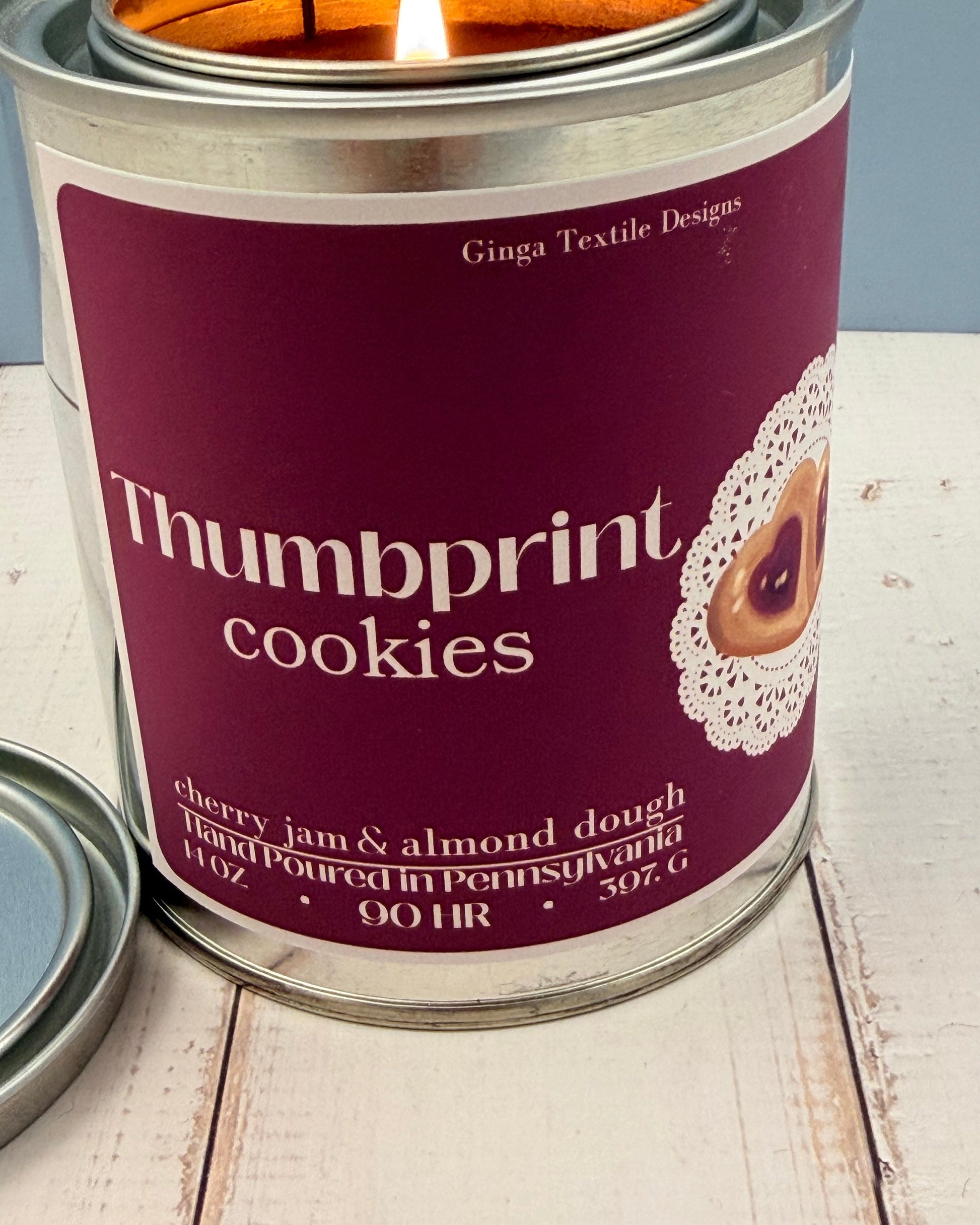 Canister of 'Thumbprint Cookies' with a purple label on a wooden surface