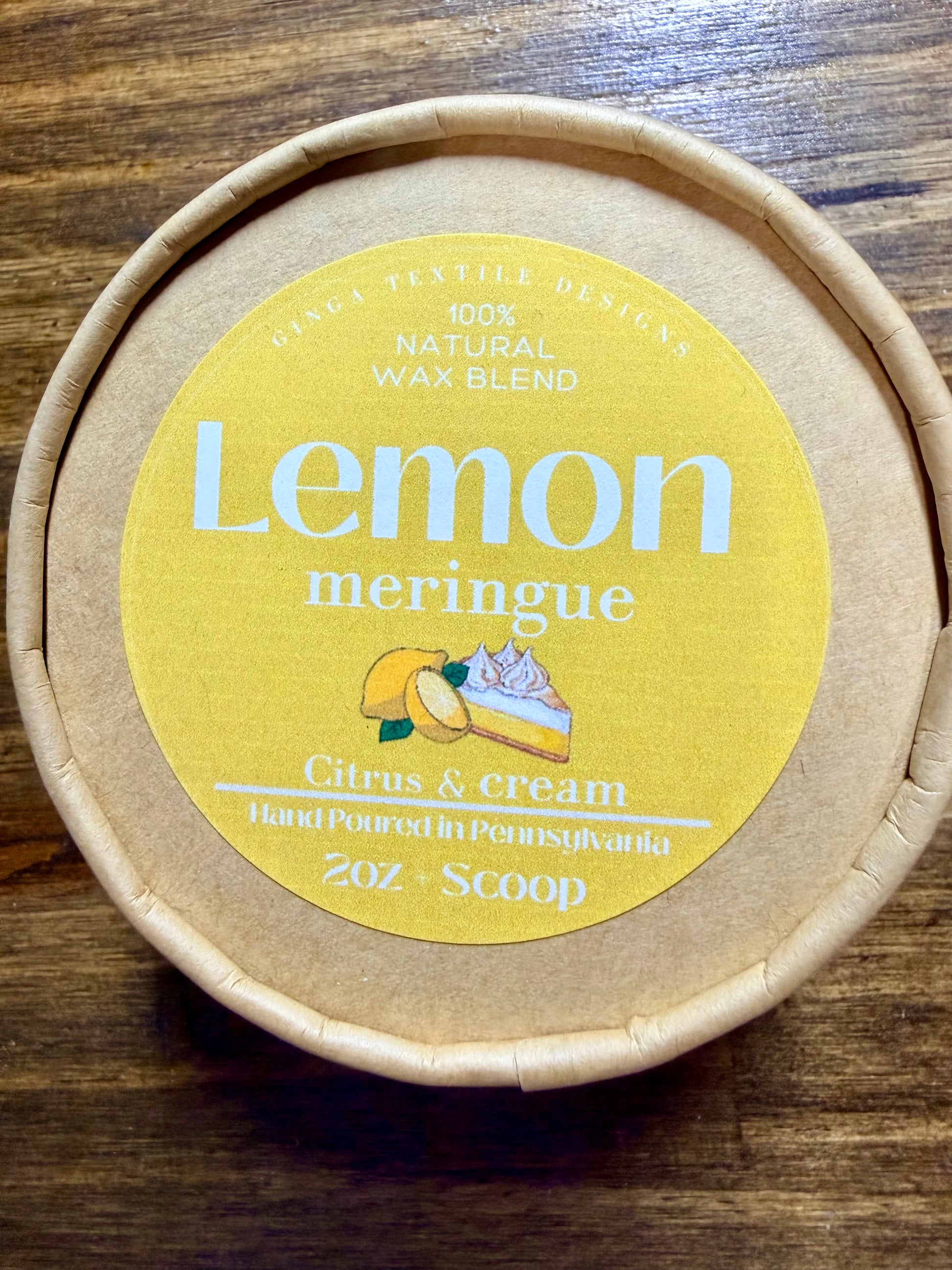 Round container with 'Lemon meringue' label on a wooden surface