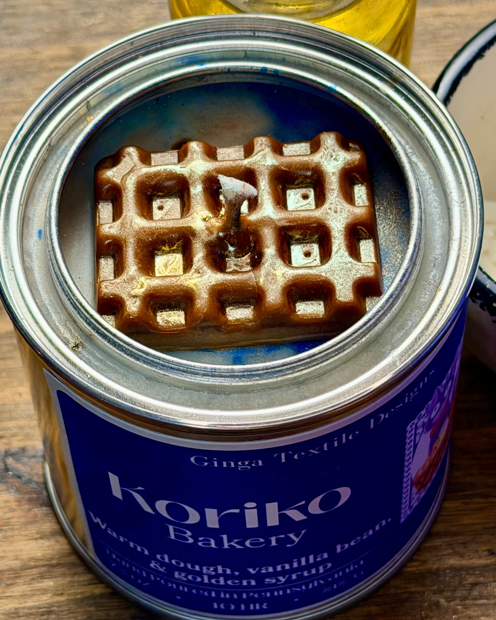 Waffle inside a can labeled 'Koriko Bakery' on a wooden surface