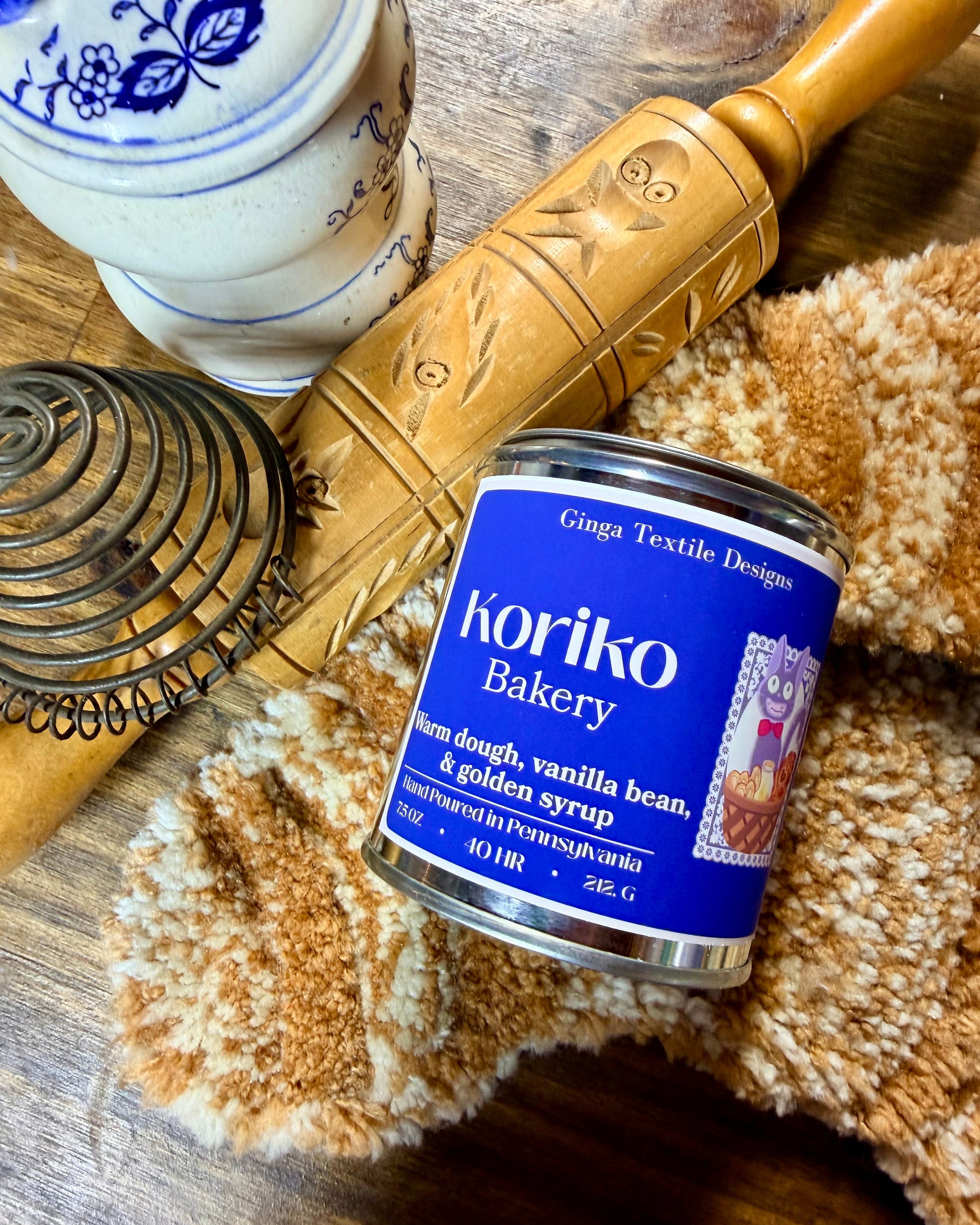 Koriko Bakery can on a wooden surface with a textured fabric and rolling pin.
