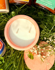 Terracotta container with a white lid on grass with small flowers
