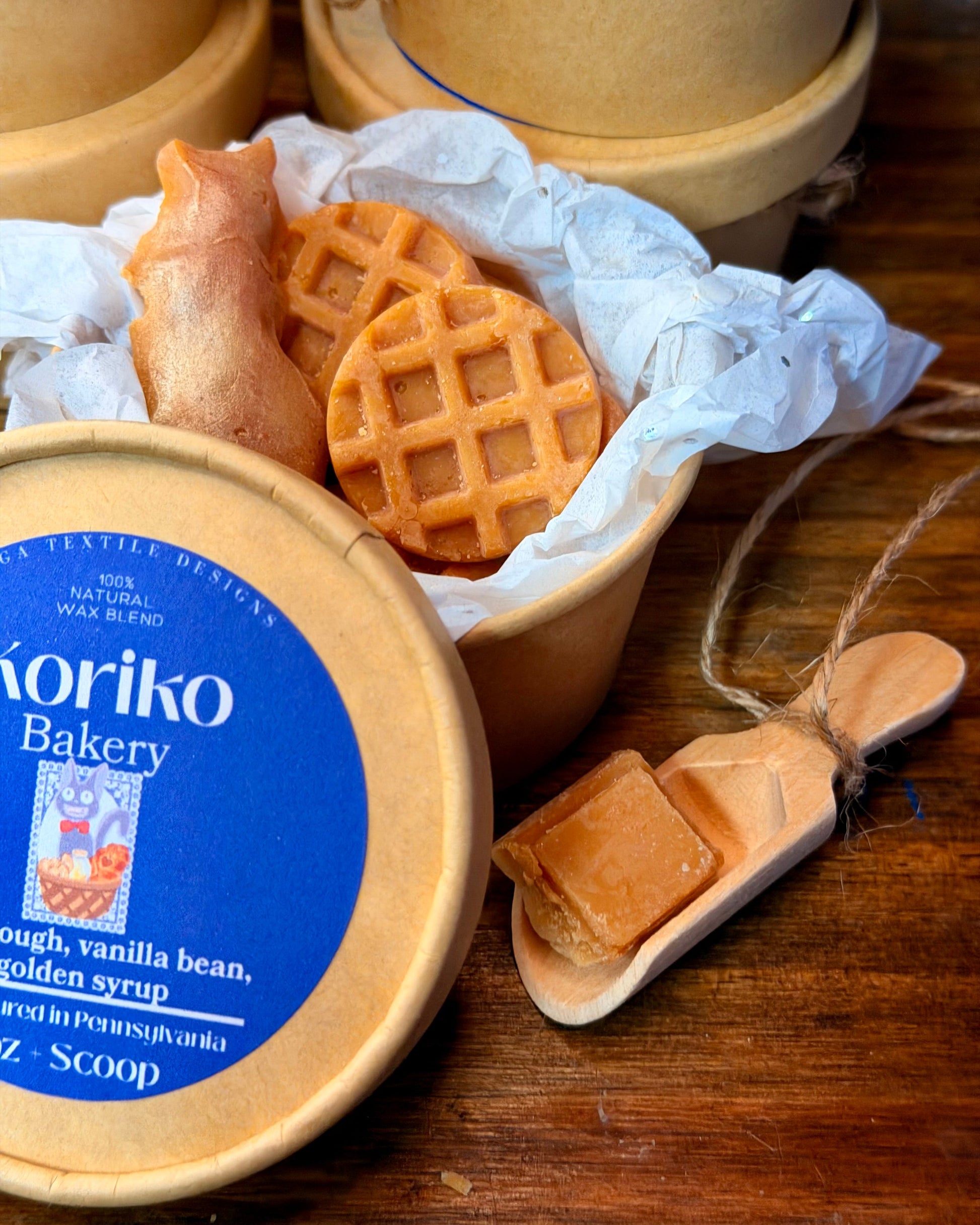 Koriko Bakery container with waffle cookies on a wooden surface