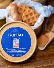 Koriko Bakery container with waffles in the background on a wooden surface