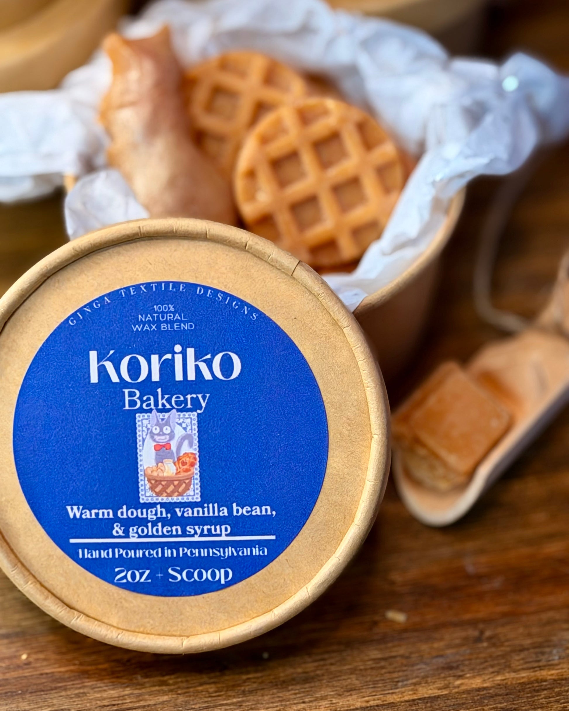 Koriko Bakery container with waffles in the background on a wooden surface