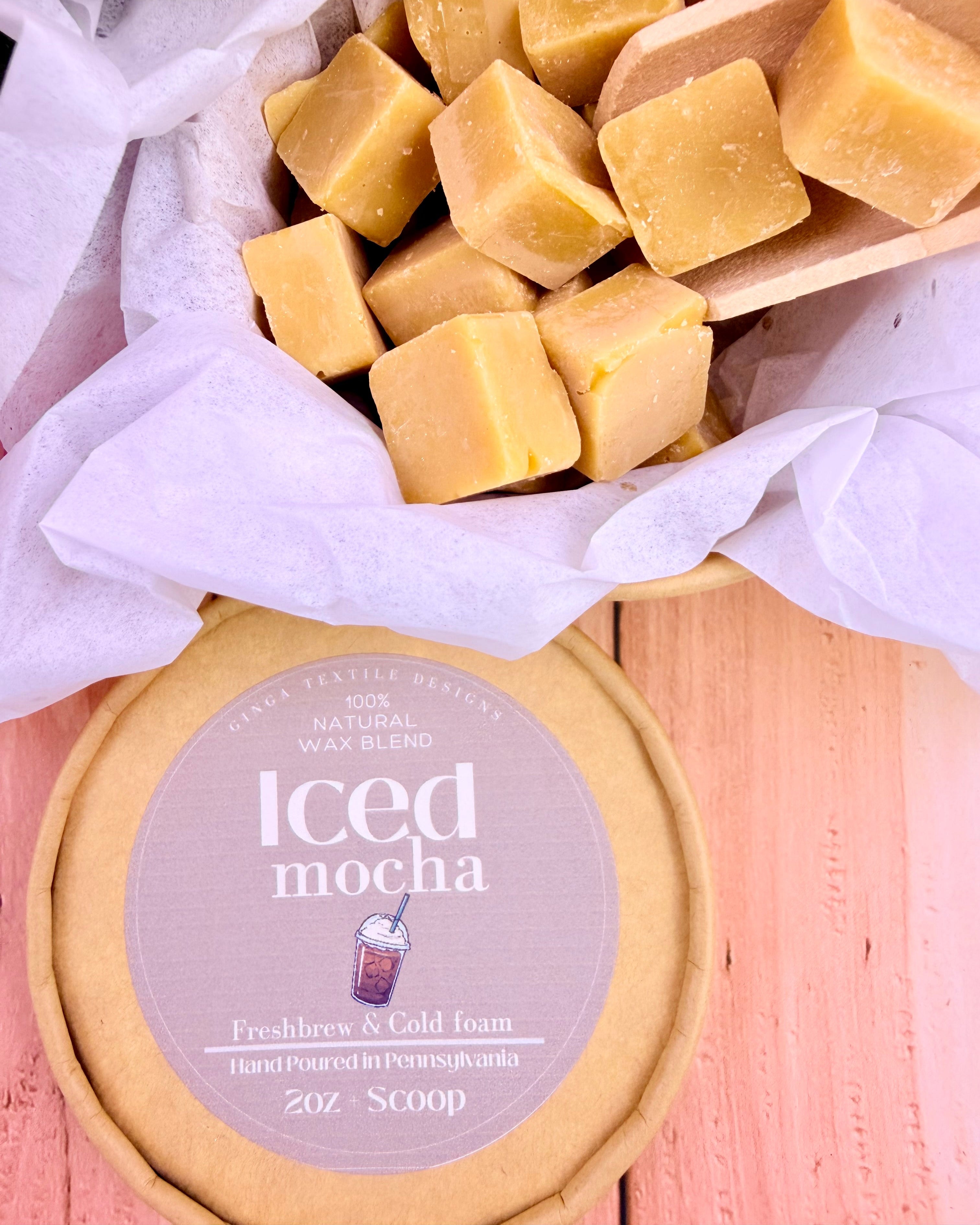 Wax melts with a lid from packaging scent iced mocha sitting on a light-colored wood surface