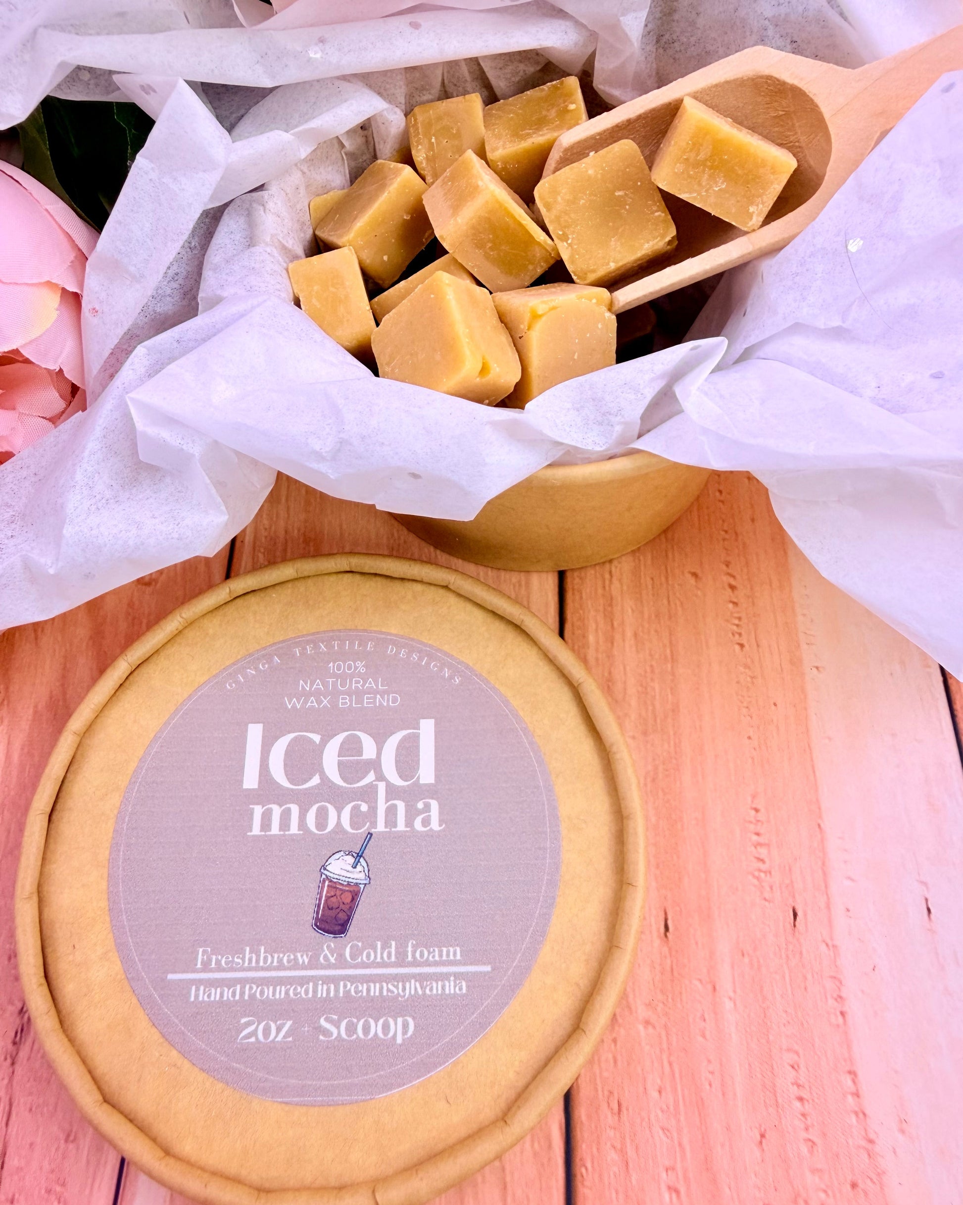 Iced Mocha wax melts packaging on a light wood surface and flowers