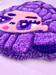 Purple and pink textured rug on a white background