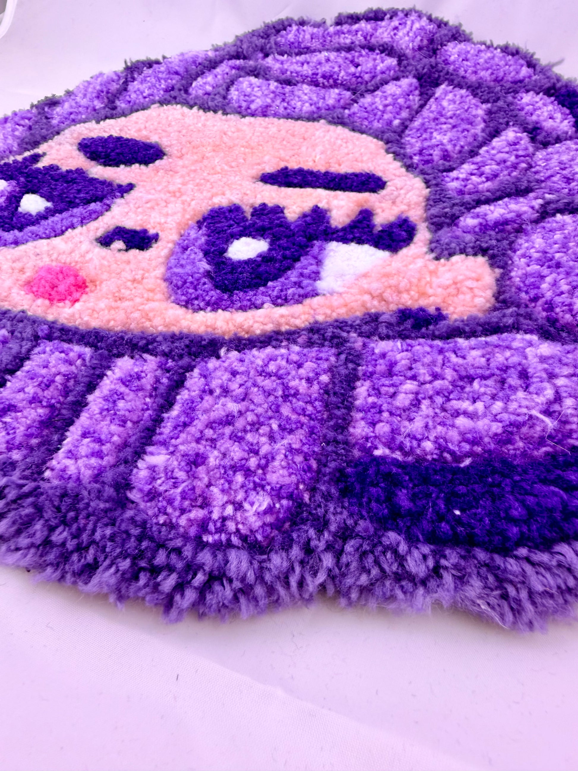 Purple and pink textured rug on a white background