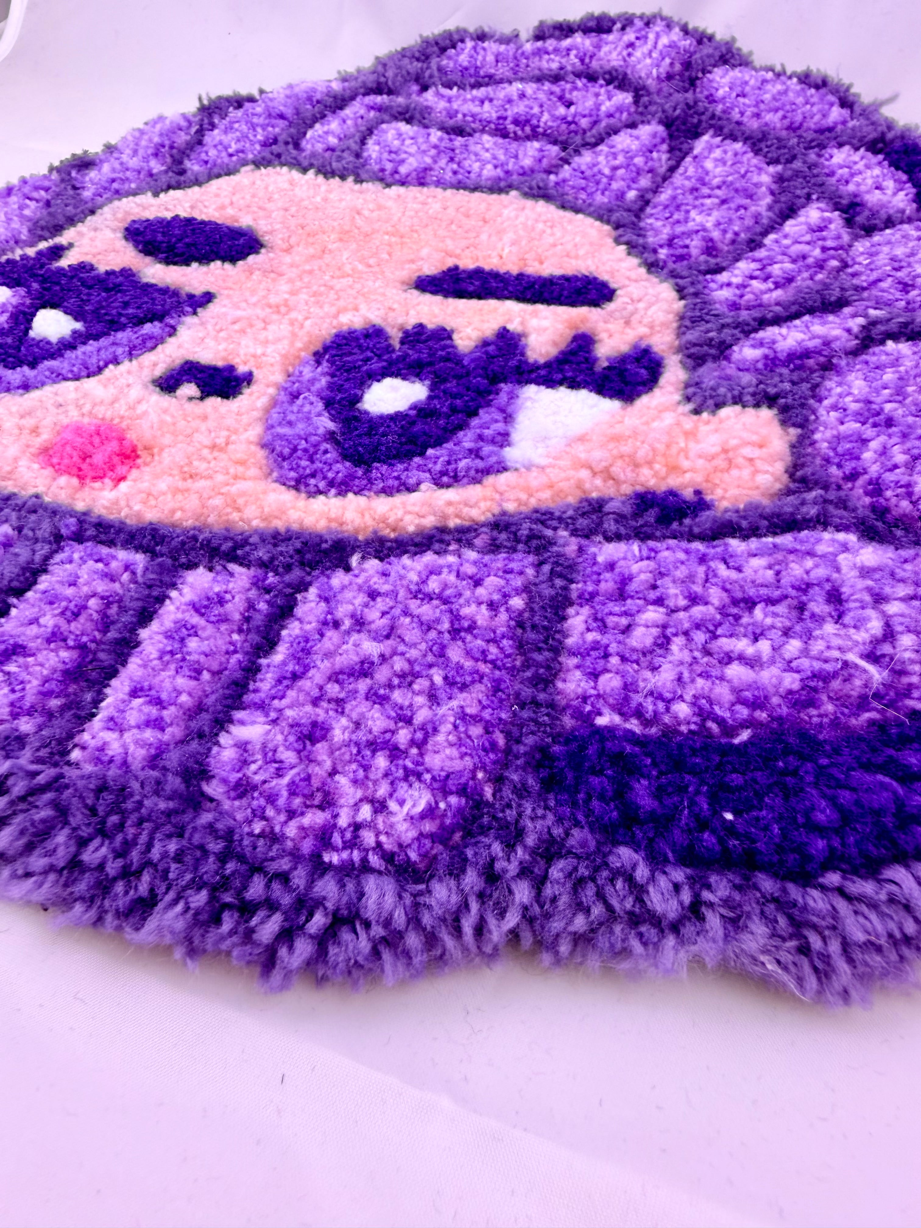 Purple and pink textured rug on a white background