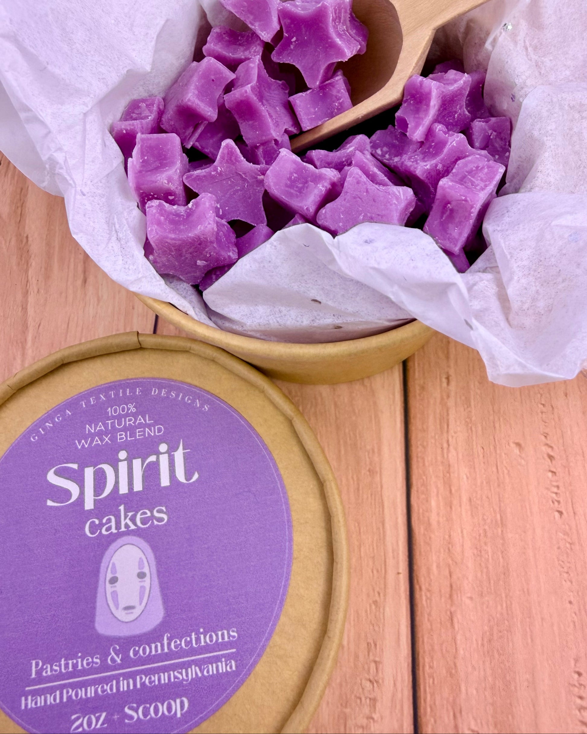 Purple star-shaped wax melts in a container with a wooden scoop, branded 'Spirit cakes'.