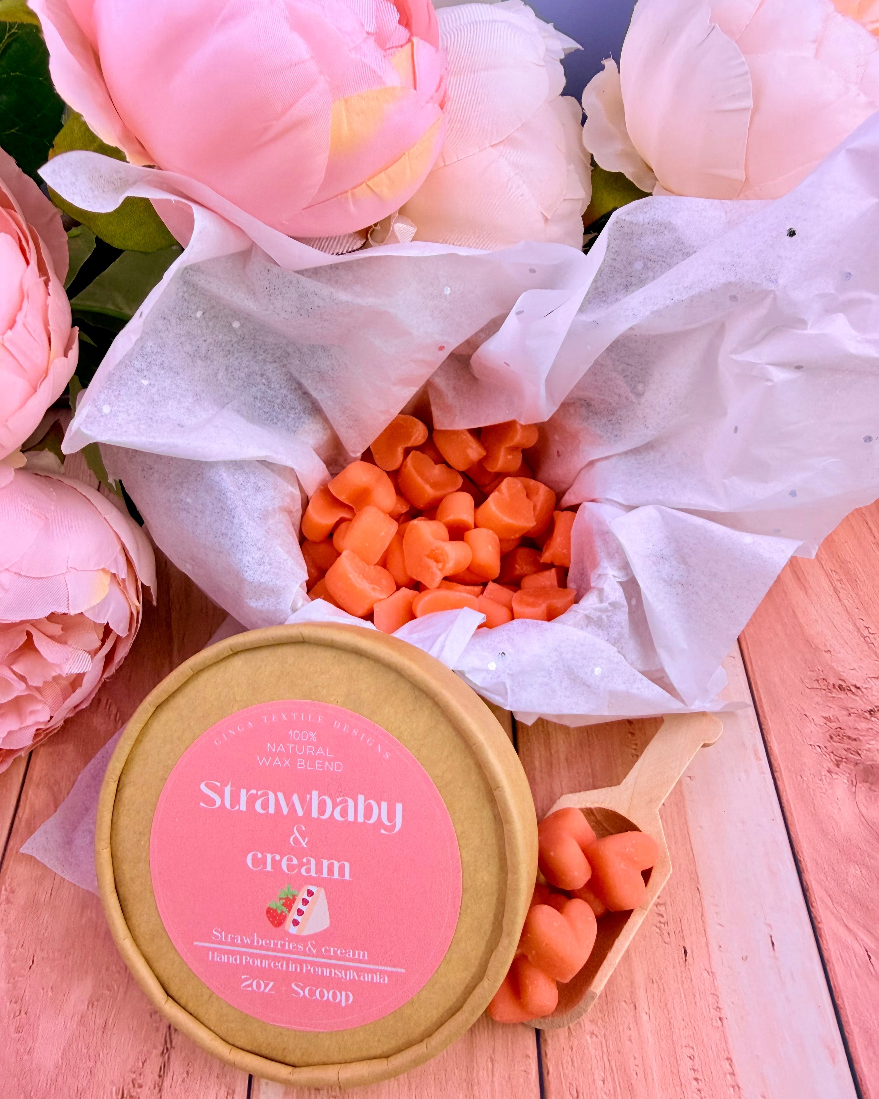 Bouquet of pink flowers with a container labeled 'Strawbaby & Cream' on a wooden surface.