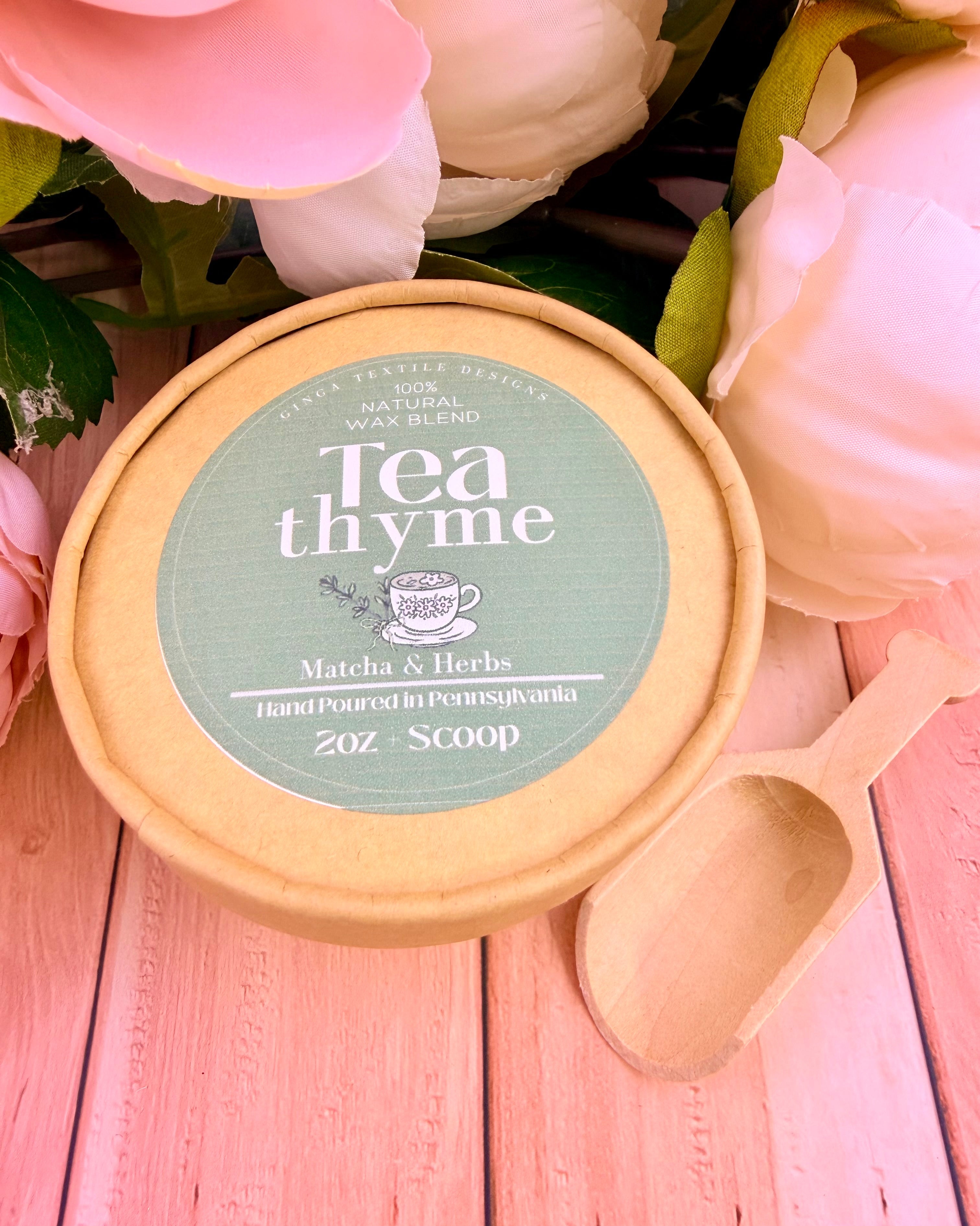 Tea thyme product container with a wooden scoop on a pink floral background