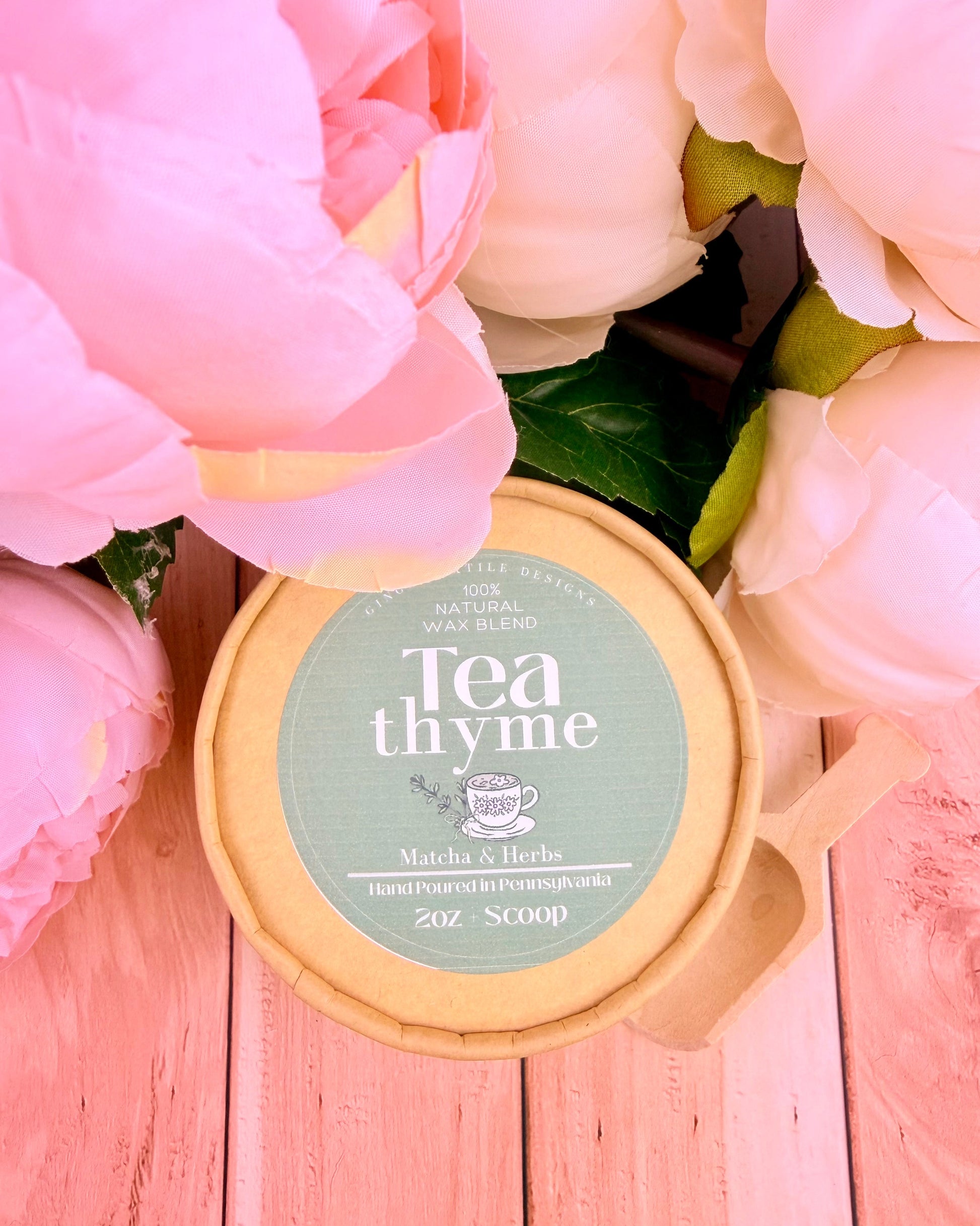 Tea thyme product container with pink flowers in the background