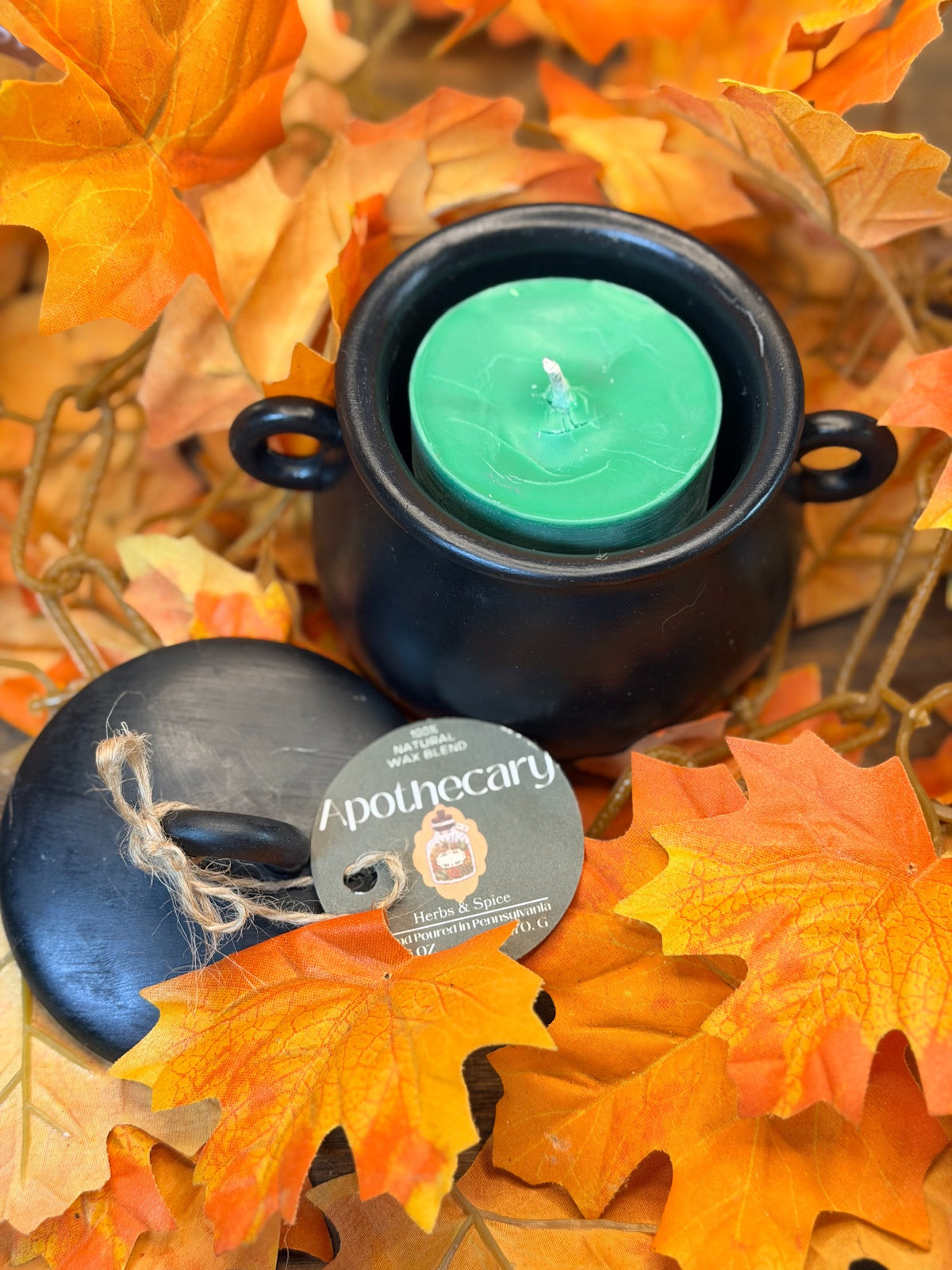 Apothecary 6 oz green pillar candle in black Hydrostone cauldron with autumn leaves